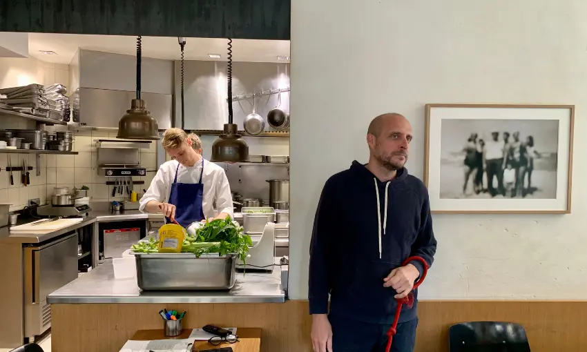 Lo chef Passerini, con la sua cucina sullo sfondo