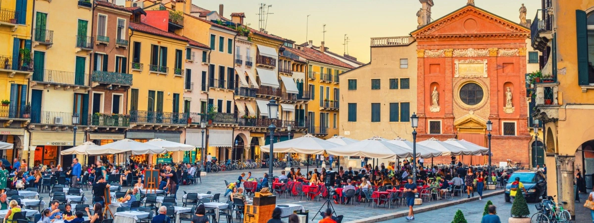 Piazza di Padova piena di ristoranti con tavoli all'aperto