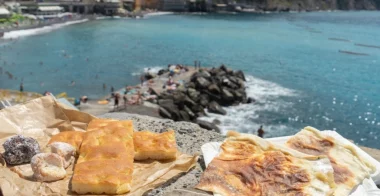 Focaccia ligure con sfondo sul paesaggio ligure