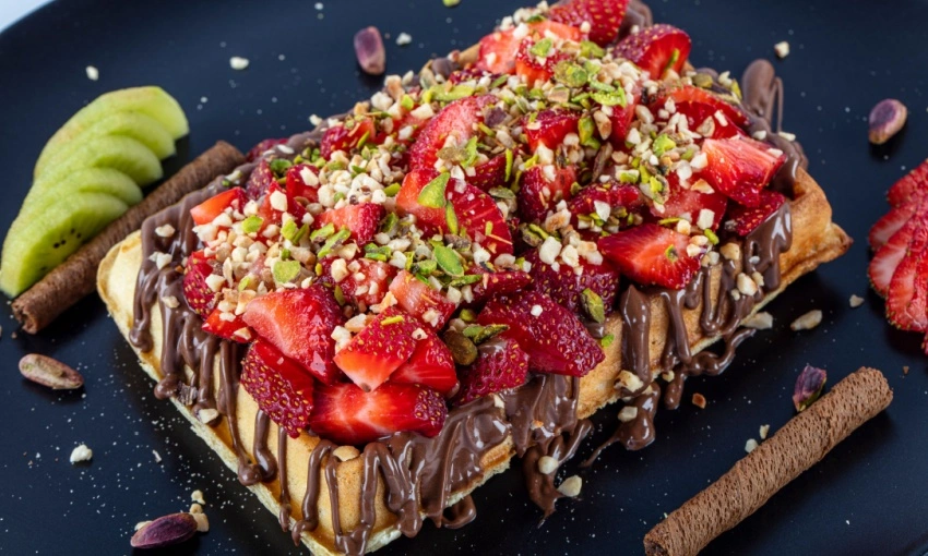 Waffle, dolce tipico della tradizione belga, con cioccolato, nocciole e fragole