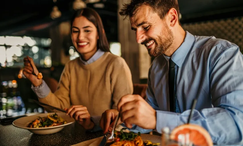 Coppia a tavola che mangia e chiacchiera