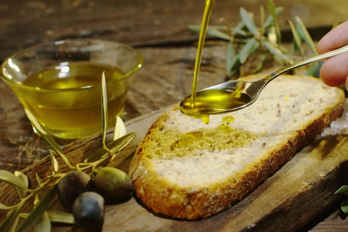 Degustazione di olio su una fetta di pane, prassi sempre più frequente grazie anche all'oleoturismo