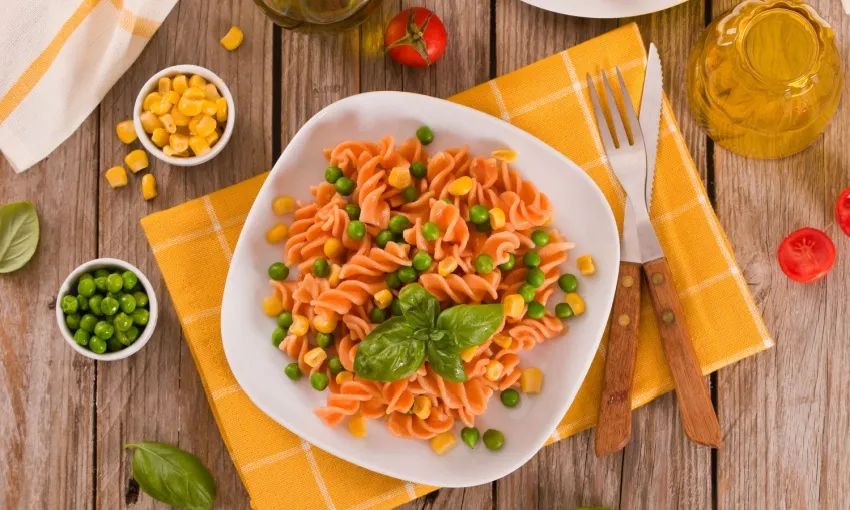 Pasta di farina di lenticchie con piselli e pomodoro