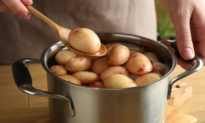 Pentola colma di patate con la buccia da bollire