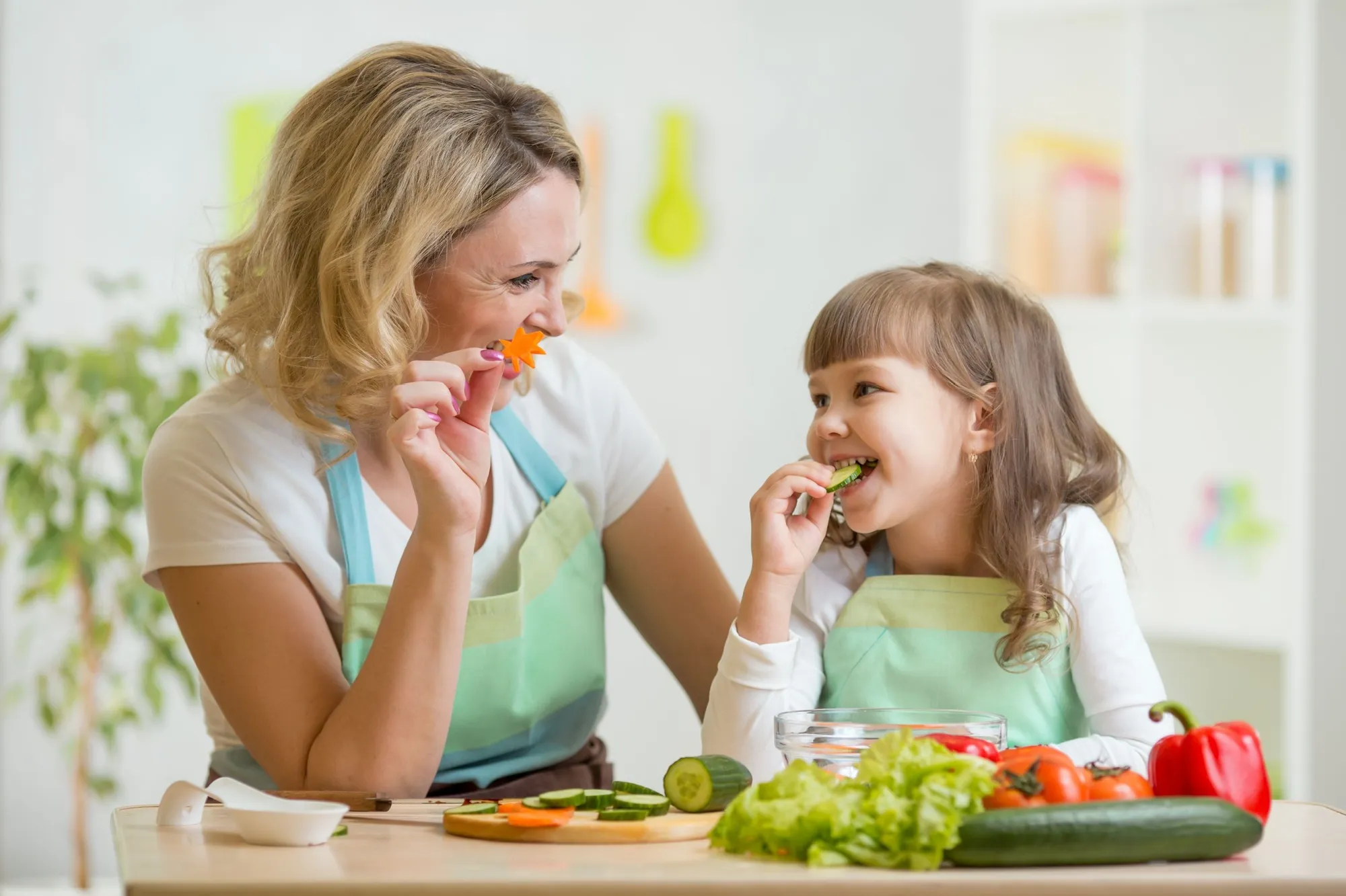 Mamma e figlia che mangiano verdure