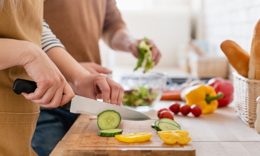 donna che taglia verdure su un tagliere