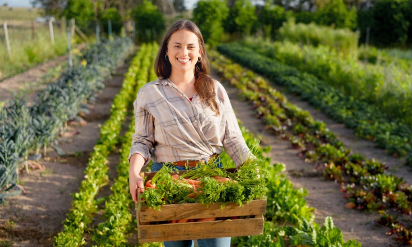 Donna con cassa di verdure appena raccolte