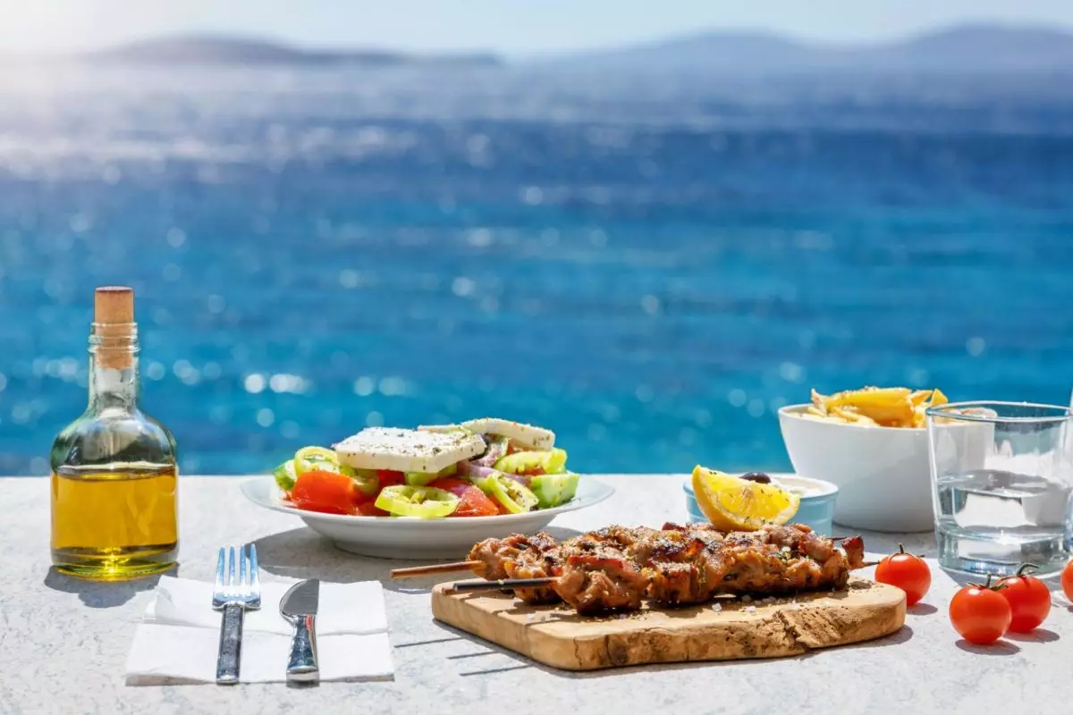 vista sul mare con piatti tipici della cucina greca in primo piano