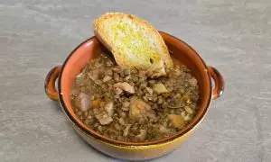 Tegame con zuppa di lenticchie e castagne pronta con pane crostato e filo d'olio evo