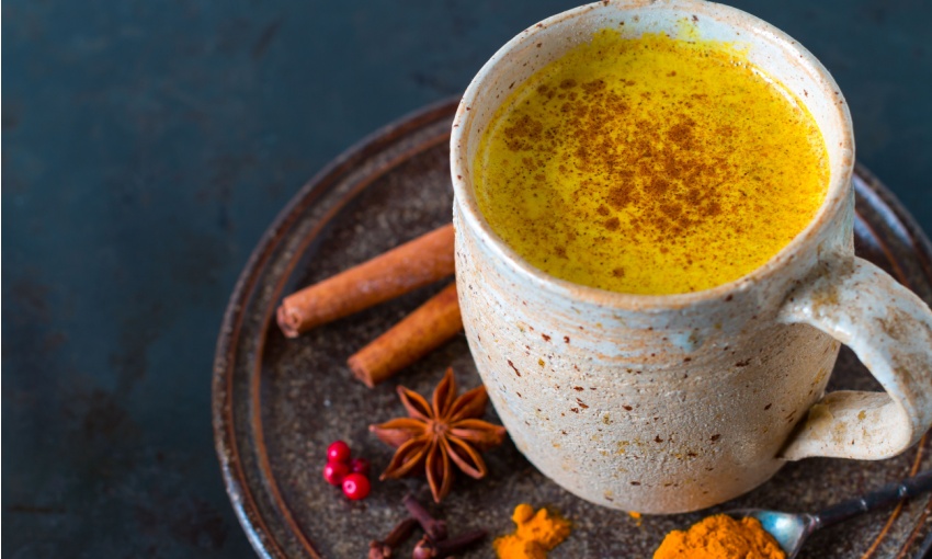 Tazza di latte d'oro con spolverata di cannella